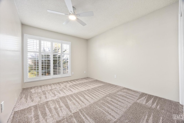 carpeted spare room featuring a textured ceiling and ceiling fan