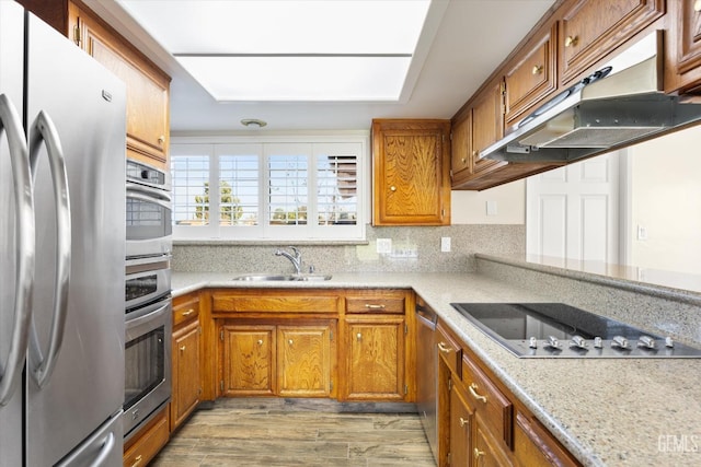 kitchen featuring light hardwood / wood-style flooring, sink, stainless steel appliances, and light stone countertops