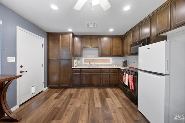 6202 Ocean Jasper Dr, Bakersfield, CA 93313 - kitchen with freestanding refrigerator, black gas range, wood finished floors, a ceiling fan, and light countertops