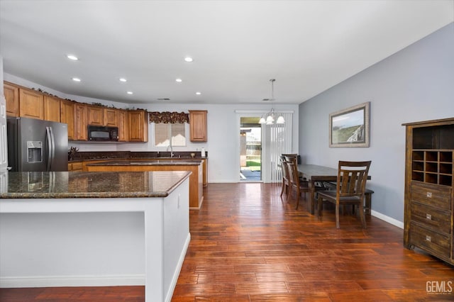 6202 Ocean Jasper Dr, Bakersfield, CA 93313 - kitchen with black microwave, stainless steel fridge, dark wood-type flooring, recessed lighting, and brown cabinets
