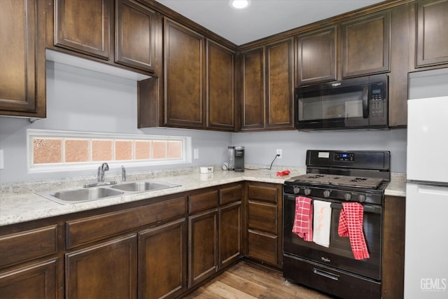 6202 Ocean Jasper Dr, Bakersfield, CA 93313 - kitchen with black appliances, dark brown cabinets, wood finished floors, light stone countertops, and recessed lighting