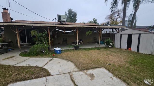 back of property with a storage unit, a patio area, and a lawn