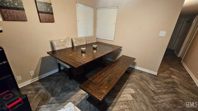 dining space featuring dark parquet floors