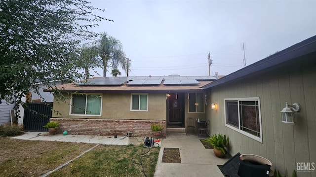 view of front facade featuring a front yard and solar panels