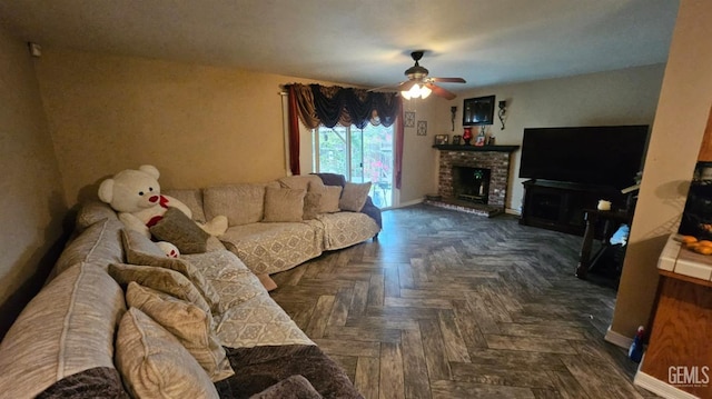 living room featuring a fireplace, dark parquet flooring, and ceiling fan