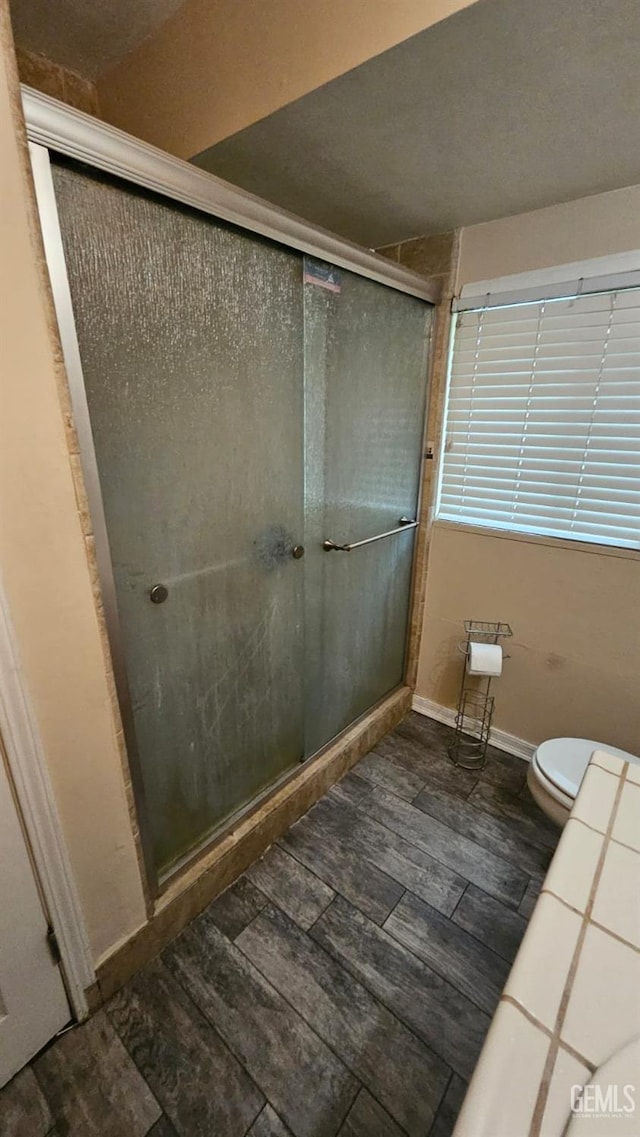 bathroom featuring toilet and walk in shower