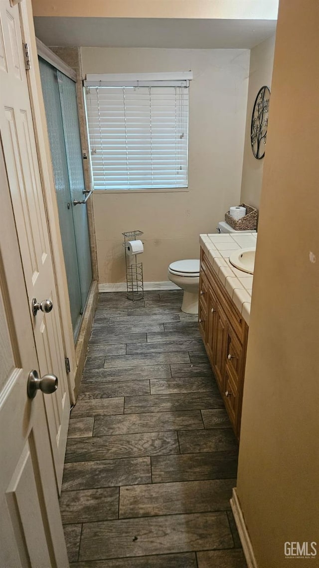 bathroom featuring vanity, toilet, and an enclosed shower