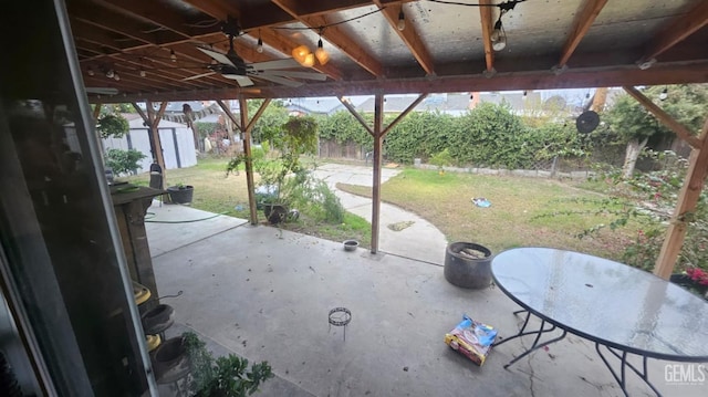 view of patio featuring ceiling fan and a shed