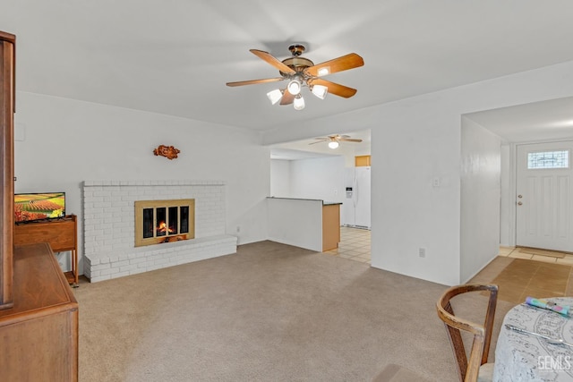 living room with a ceiling fan, carpet, and a fireplace