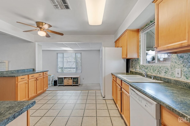 kitchen with visible vents, a sink, dark countertops, tasteful backsplash, and white appliances