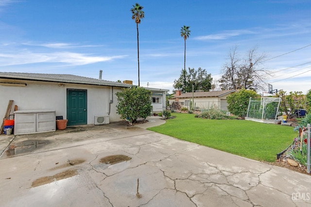 rear view of house featuring a yard and stucco siding