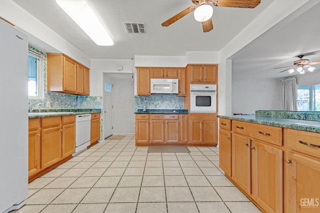 kitchen with light tile patterned flooring, backsplash, white appliances, and a ceiling fan