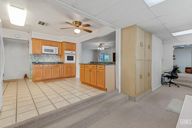 kitchen featuring white appliances, a ceiling fan, visible vents, decorative backsplash, and dark countertops