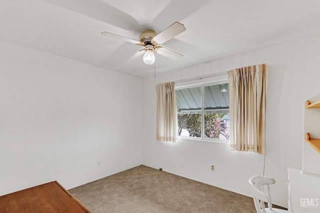 carpeted empty room featuring a ceiling fan