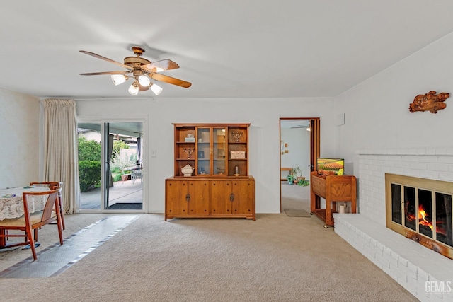 sitting room featuring light carpet, a fireplace, and ceiling fan