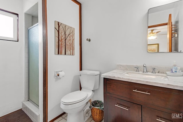 bathroom featuring vanity, a shower stall, and toilet