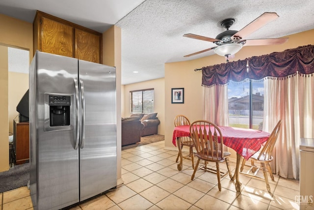 dining area with light tile patterned floors, a textured ceiling, and ceiling fan
