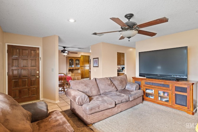 tiled living room with a textured ceiling, visible vents, and a ceiling fan