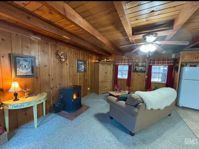 living room featuring wooden walls, a wood stove, and wooden ceiling