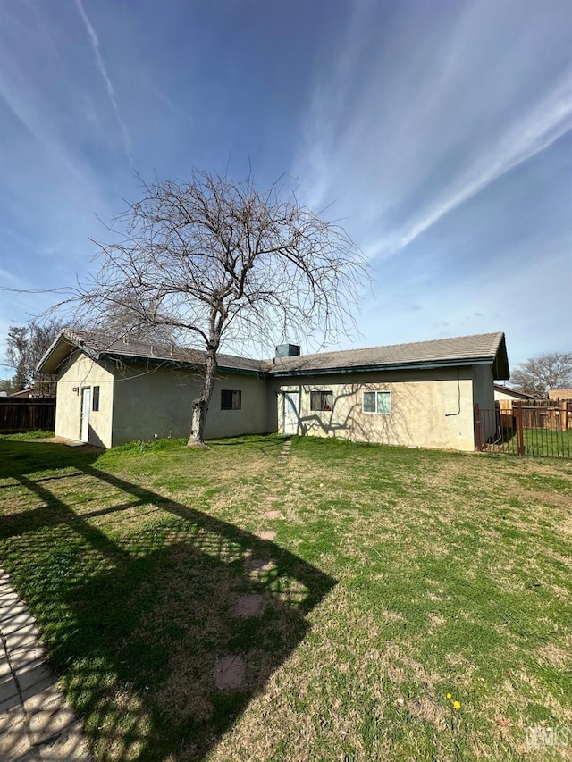 rear view of property with a yard and a storage shed