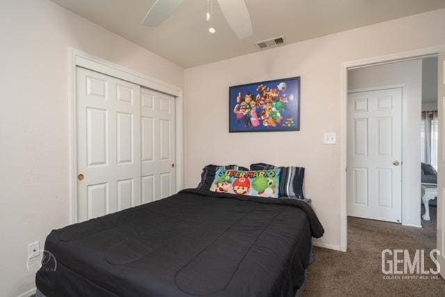 bedroom with ceiling fan, dark carpet, and a closet