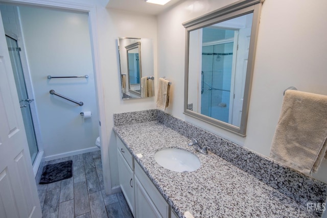 1805 Glenbrea Ct, Bakersfield, CA 93309 - bathroom featuring vanity, toilet, baseboards, an enclosed shower, and wood tiled floor