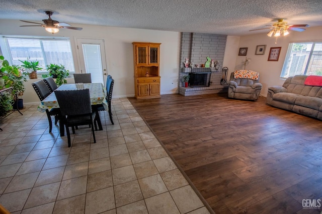 1805 Glenbrea Ct, Bakersfield, CA 93309 - dining space featuring tile patterned floors, a ceiling fan, a brick fireplace, and a textured ceiling