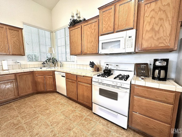 10304 Blythe Ct, Bakersfield, CA 93311 - kitchen featuring white appliances, tile counters, and brown cabinetry