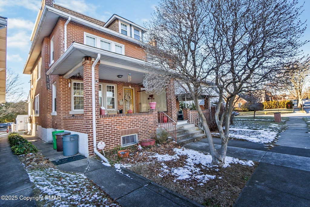 view of front of home featuring a porch and brick siding