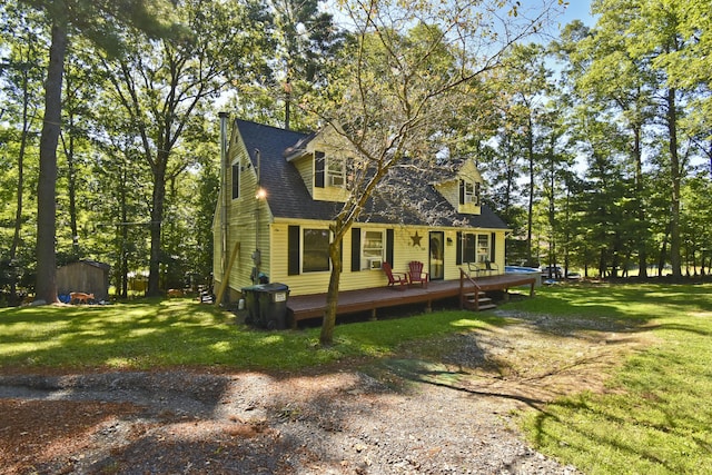 exterior space featuring a shingled roof, a yard, a deck, an outdoor structure, and a storage unit