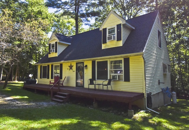 new england style home with a front lawn, cooling unit, and a wooden deck