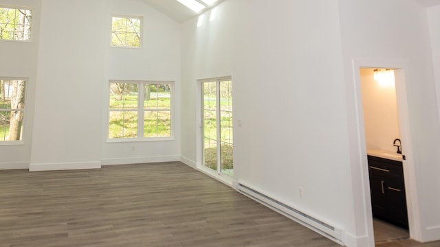 119 N Shore Dr, Albrightsville, PA 18210 - unfurnished living room with a baseboard heating unit, high vaulted ceiling, a sink, wood finished floors, and plenty of natural light