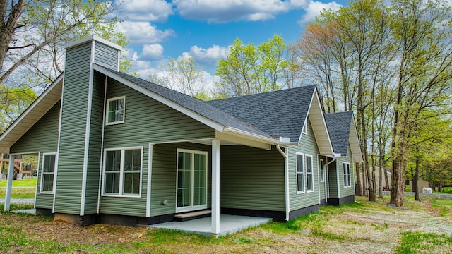 119 N Shore Dr, Albrightsville, PA 18210 - view of side of home featuring a chimney, roof with shingles, and a patio area