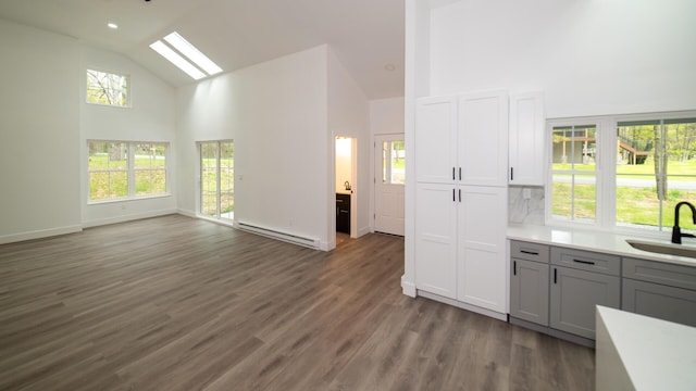 119 N Shore Dr, Albrightsville, PA 18210 - kitchen featuring high vaulted ceiling, baseboard heating, a sink, a skylight, and light countertops
