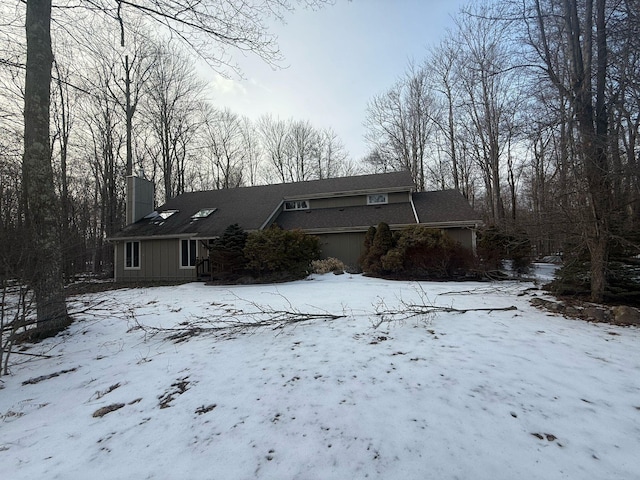 view of front of home with a chimney and an attached garage