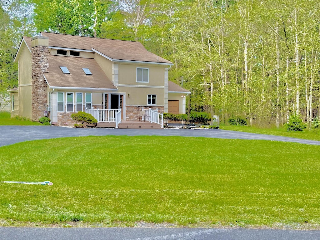 111 Sir Lyonnesse Ct, Pocono Lake, PA 18347 - view of front of home featuring stone siding, a front lawn, driveway, and a chimney