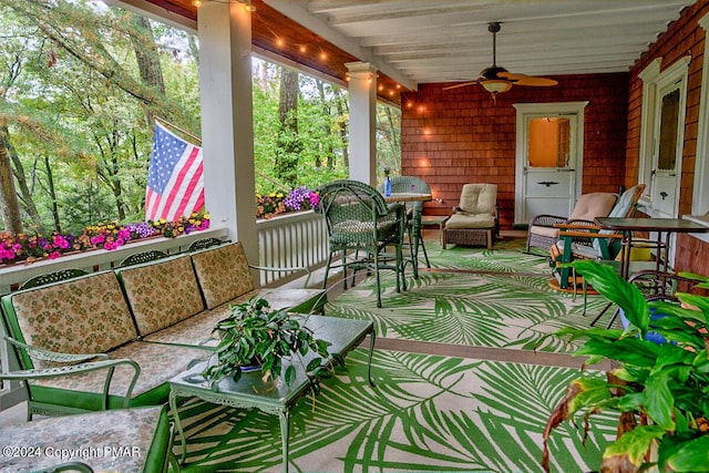 sunroom / solarium with ceiling fan and beamed ceiling