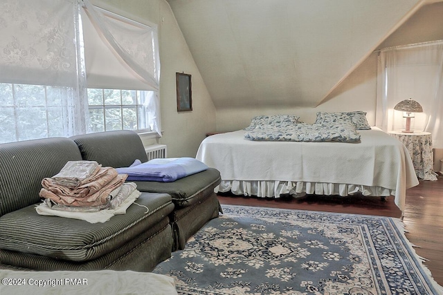 bedroom featuring lofted ceiling and wood finished floors