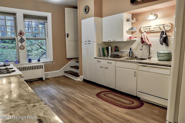 kitchen with wood finished floors, light countertops, backsplash, dishwasher, and radiator heating unit