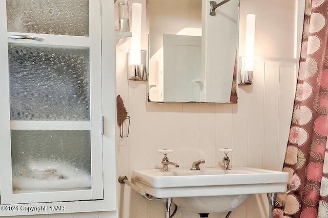 bathroom featuring curtained shower and a sink