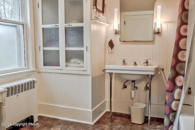 full bath featuring radiator, a healthy amount of sunlight, and curtained shower