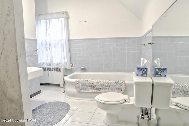 bathroom featuring a bathtub, radiator, toilet, and tile patterned floors