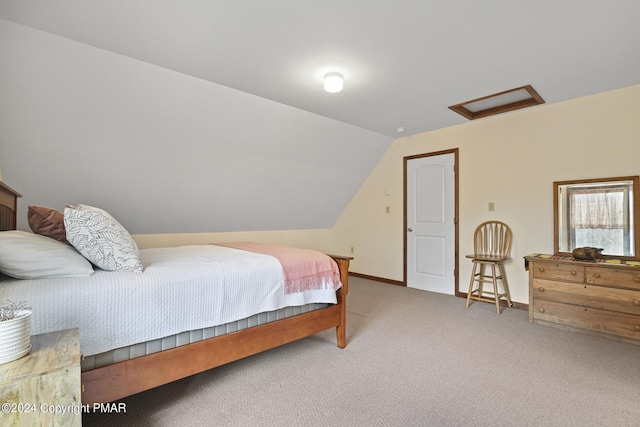 carpeted bedroom with vaulted ceiling, attic access, and baseboards