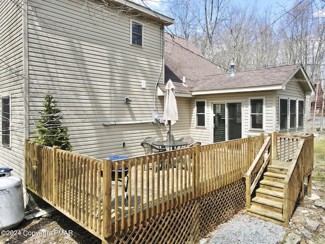 back of house with a shingled roof and a wooden deck