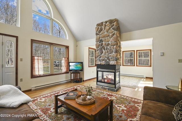 living room featuring a fireplace, a baseboard radiator, and wood finished floors