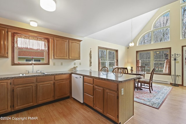 kitchen with white dishwasher, a peninsula, a sink, light wood finished floors, and brown cabinetry