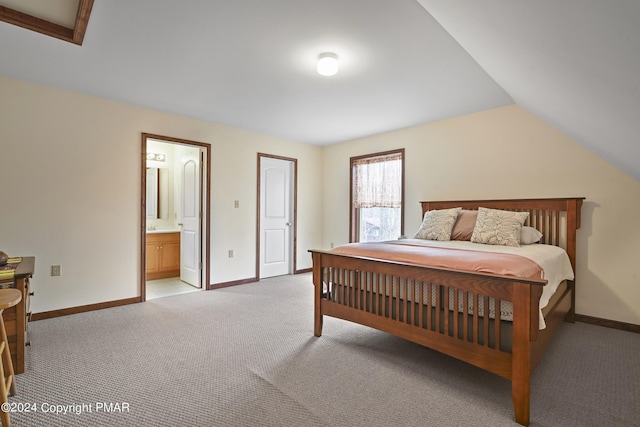 bedroom with connected bathroom, light carpet, vaulted ceiling, and baseboards