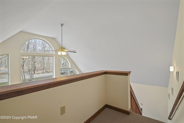 interior space featuring lofted ceiling, carpet floors, ceiling fan, and baseboards