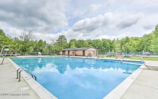 community pool featuring fence and a patio