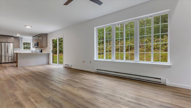 79 Delaware Dr, Jim Thorpe, PA 18229 - unfurnished living room featuring a baseboard heating unit, ceiling fan, wood finished floors, baseboards, and a baseboard radiator